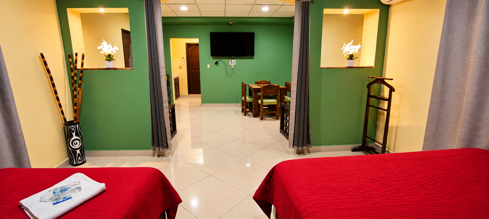 Suite moderna con camas rojas y comedor